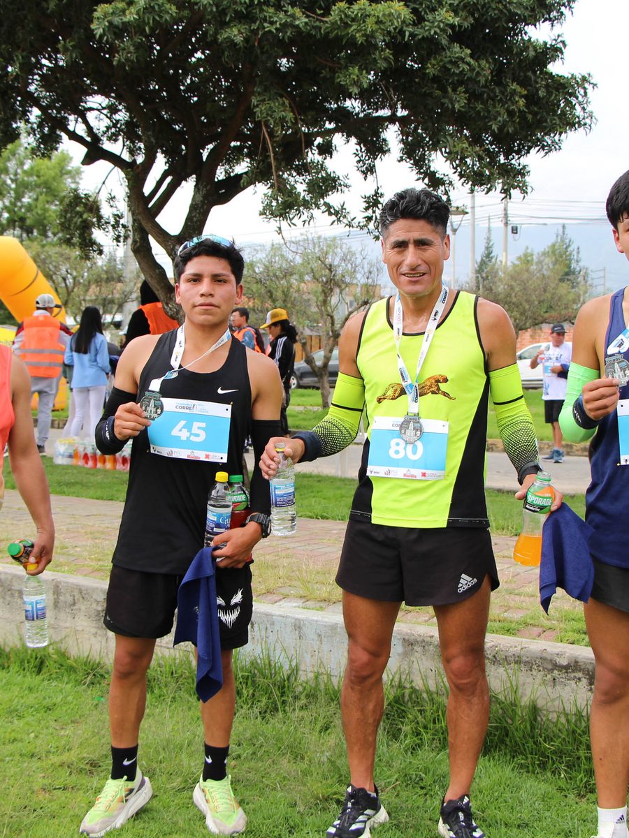 Grupo de corredores posando con sus medallas